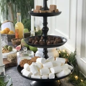 Kakfat i mörkbrun aluminium från Affari of Sweden, fyllt med godis och kakor i tre våningar på ett juligt dukat bord.