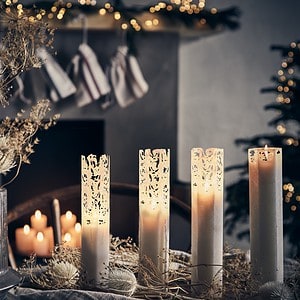 En vacker juldukning med spindelvävsljus från Affari of Sweden, omgivna av torkade växter och juldekorationer i en mysig miljö.