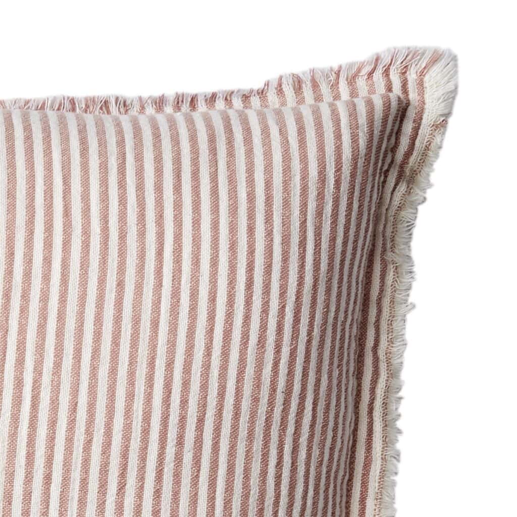 Närbild på fransarna och mönstret på kuddfodralet LINE i rosa och vit randig design.
