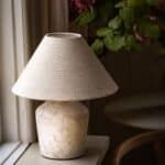 Lampfot Bodil från Strömshaga i marmorliknande beige keramik med klassisk textilskärm – perfekt för en varm och tidlös inredning.