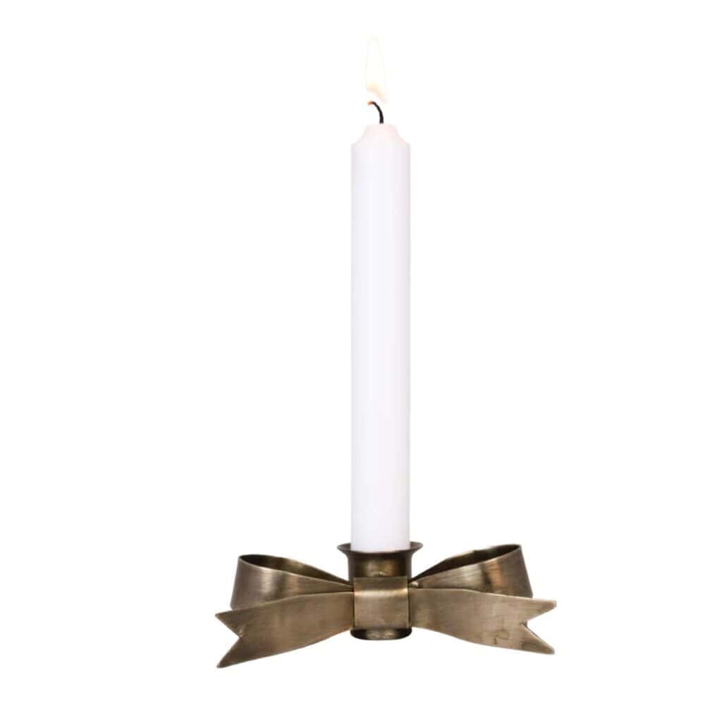 Ljushållare Tove Rosett i antik mässing med ett vitt kronljus, formad som en elegant rosett.