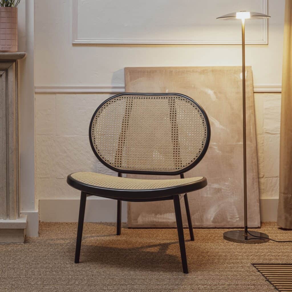 Loungefåtölj Spike från Zuiver i en stilren inredning – en elegant fåtölj med sits och rygg i flätad rotting, svart metallram och tidlös design, perfekt för en modern och varm atmosfär.