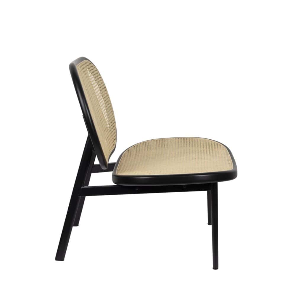 Loungefåtölj Spike från Zuiver – sidovy av den eleganta fåtöljen med flätad rotting och svart metallram, som visar dess bekväma lutning och luftiga design.