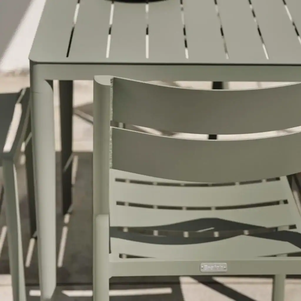 Detaljbild av DELIA matstolens rygg mot ett matchande bord i dusty green.
