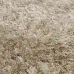 Närbild på den tjocka luggen i matta Hairy från Zuiver i beige, visad för att framhäva dess mjuka och fluffiga textur.