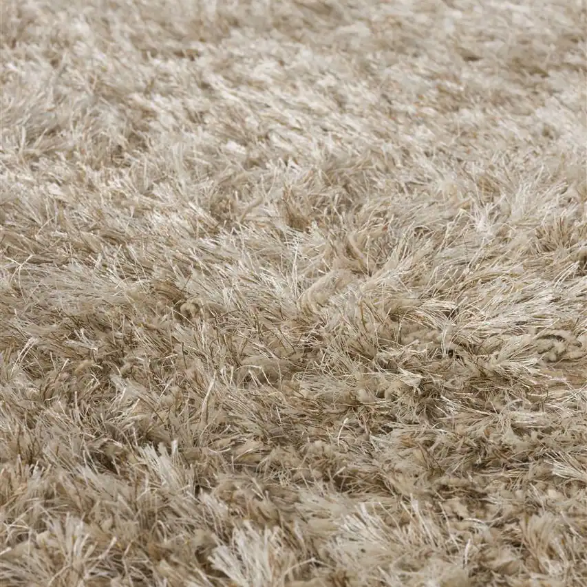 Närbild på den tjocka luggen i matta Hairy från Zuiver i beige, visad för att framhäva dess mjuka och fluffiga textur.
