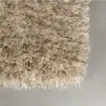 Hörn på matta HAIRY i beige från Zuiver, där den fluffiga kanten och detaljrikedomen syns tydligt.