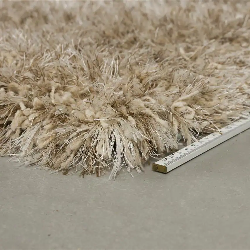 Närbild på mattan Hairy från Zuiver med måttstock som visar den tjocka och fluffiga strukturen.