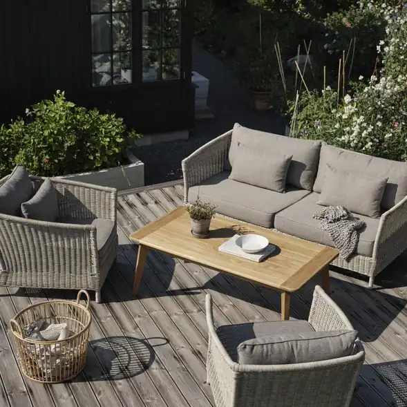 Trädgårdssoffa ASTER beige i loungemiljö på träaltan tillsammans med fåtöljer och bord