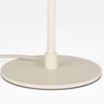 Detaljbild av bordslampa WUBBO beige från Hemlängtan, lampfot i metall med tygklädd sladd.