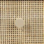 Närbild av sängbord AMAYA beige från Hemlängtan, rottingfront med beige knopphandtag.