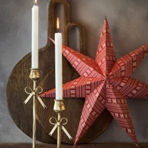 Miljöbild med röd julstjärna UNI och mässingsljusstakar – julstämning från Affari of Sweden.