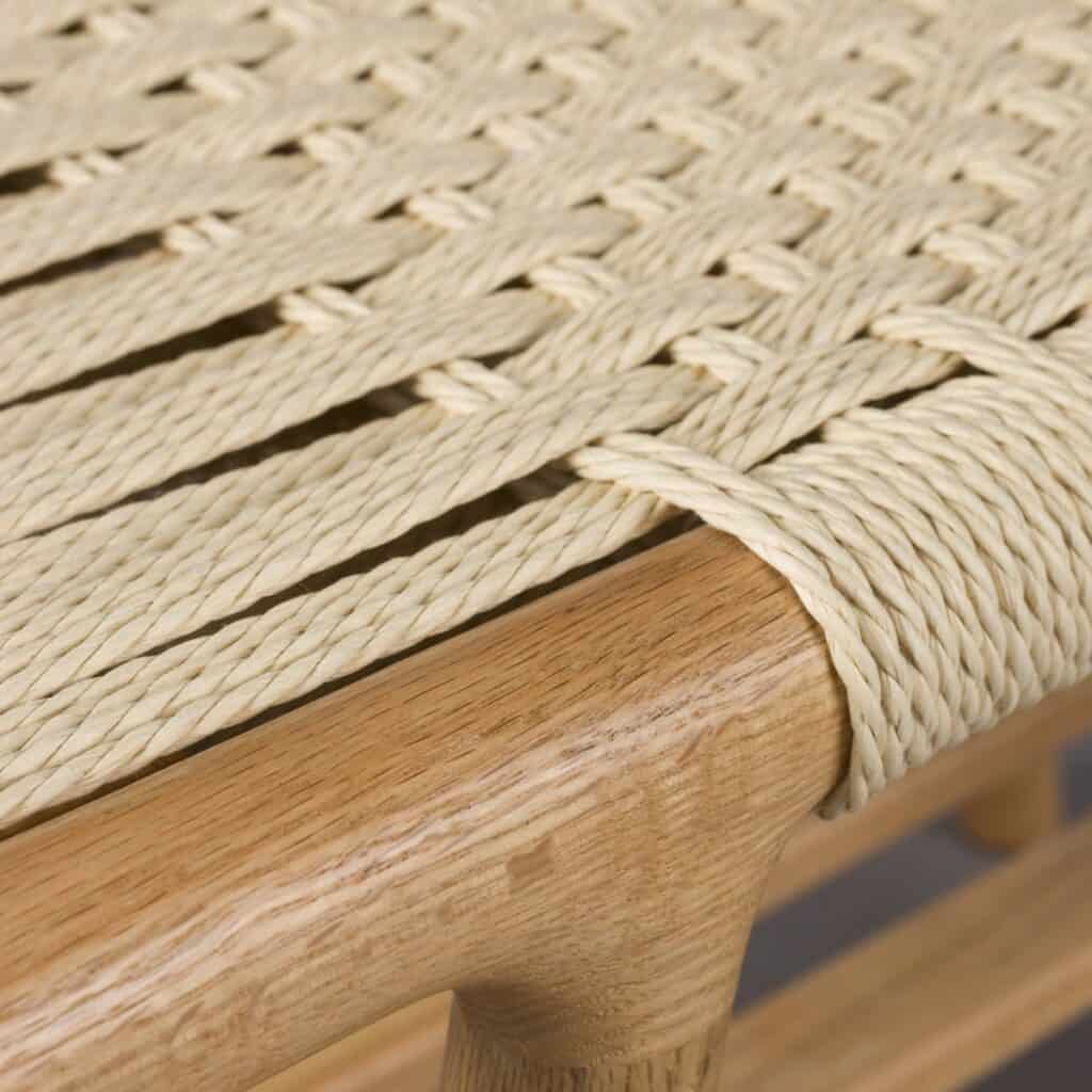 Närbild på handflätad sits i pappersrep och massiv ek på bänk