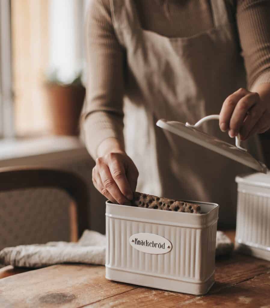 Plåtburk för knäckebröd på köksbord i lantlig stil.