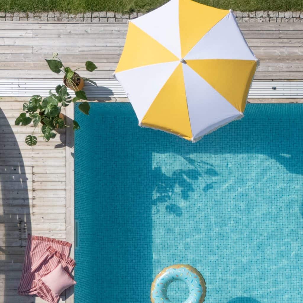 Randigt parasoll Valletta i vitt och gult vid pool